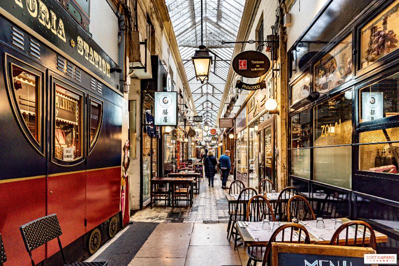 Un homme se promène dans la Galerie Vivienne près de la rue Notre-Dame-des-Victoires à Paris, admirant l'architecture des passages couverts et les boutiques.
